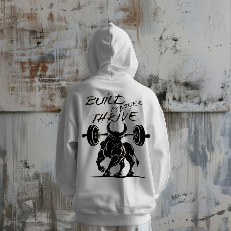 Back view of a white hoodie with a bold graphic of a muscular bull lifting barbells and the text "Built Conquer Thrive" — gym-themed custom hoodie design for fitness lovers.