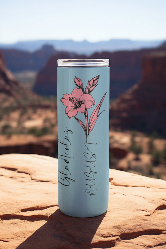 Pink flower August tumbler on rocky ledge with desert mountain background
