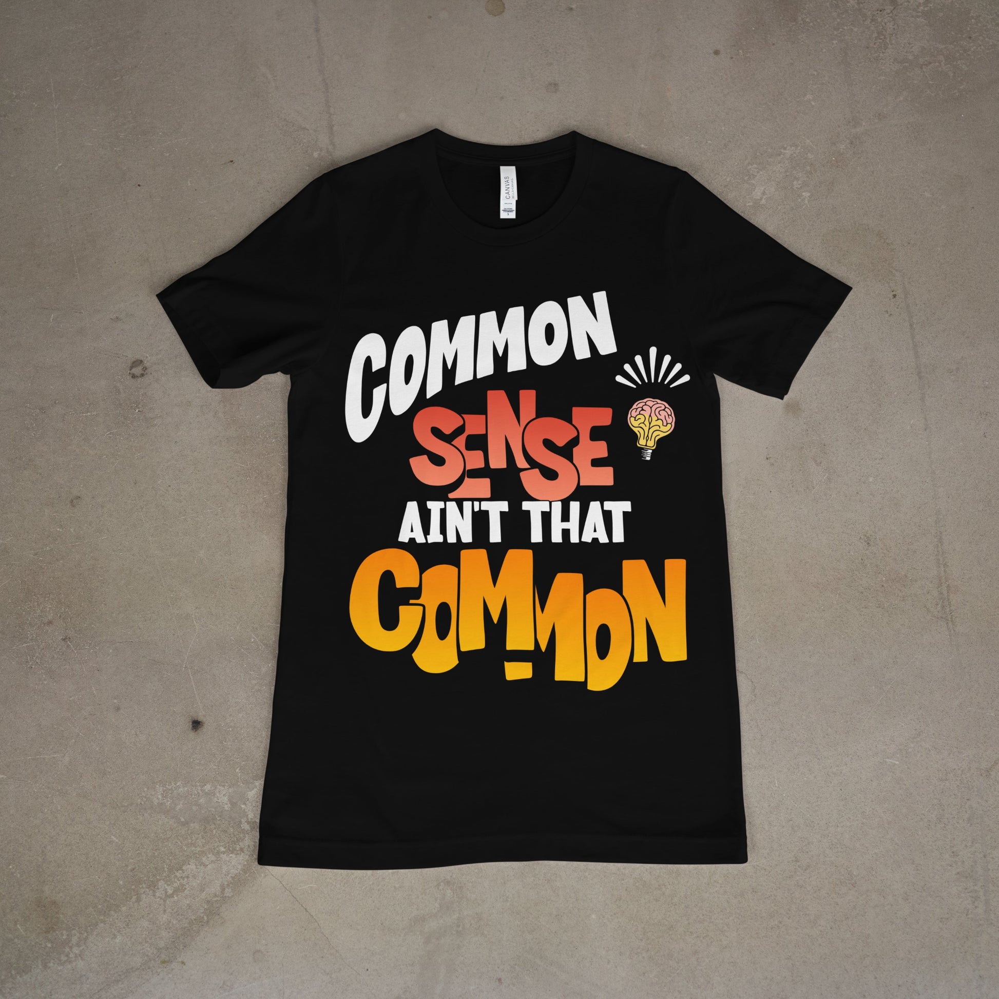 Black tee with bold text “Common Sense Ain’t That Common” in white, red, and yellow