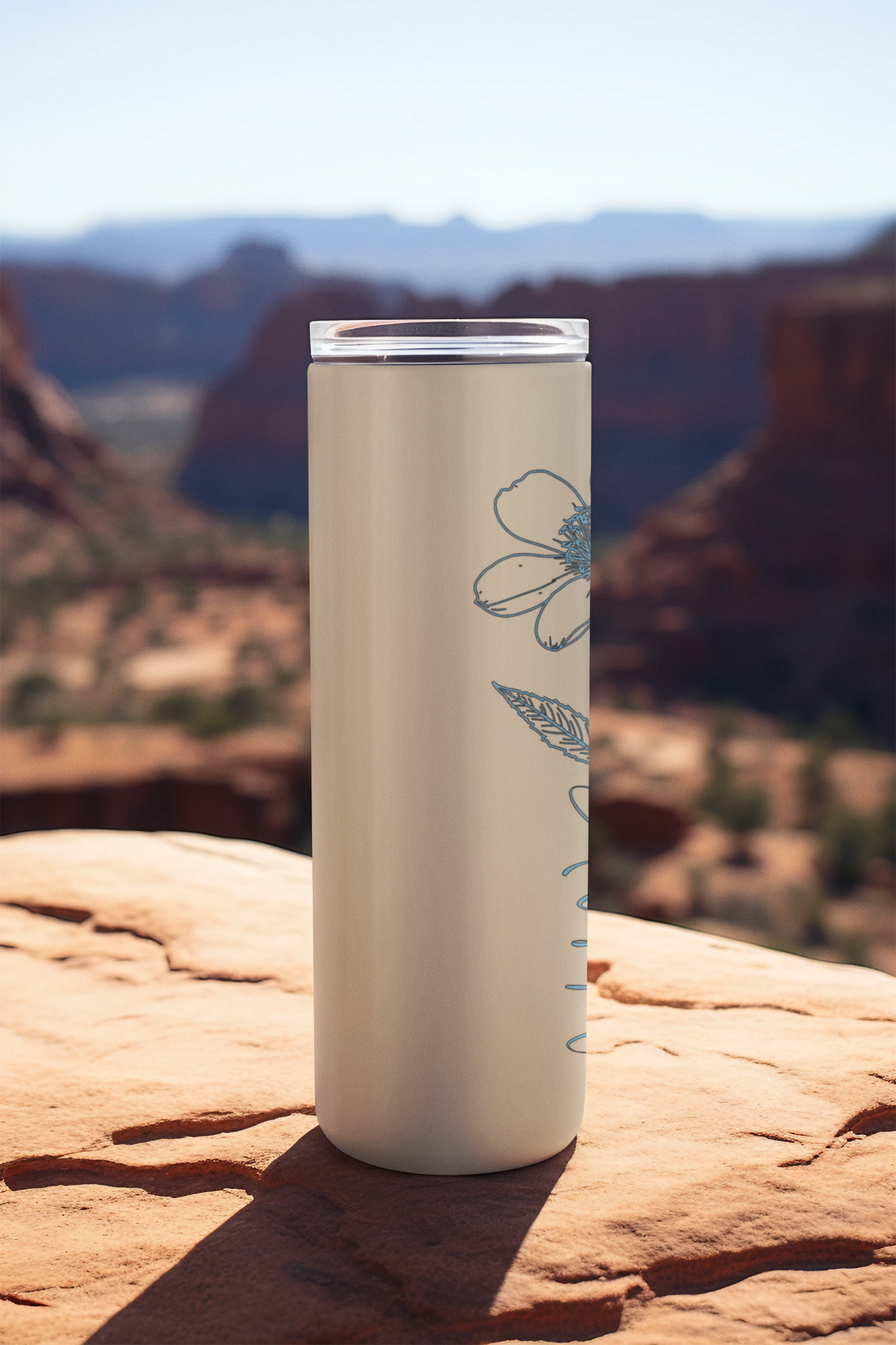 Skinny stainless steel tumbler with honeysuckle design and elegant June lettering, shown on natural backdrop