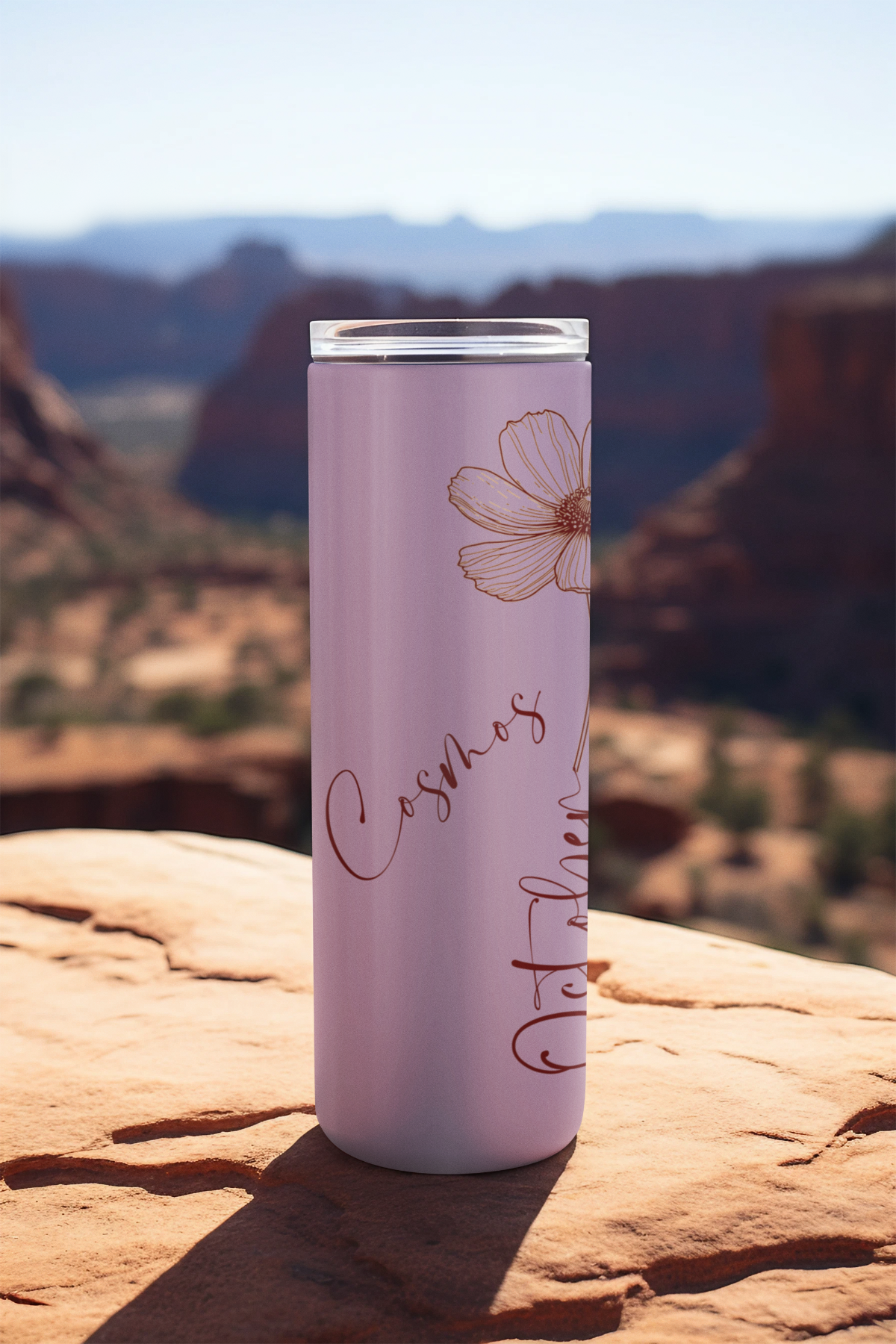 October Monthly Blooms tumbler standing on rock ledge with scenic mountain background