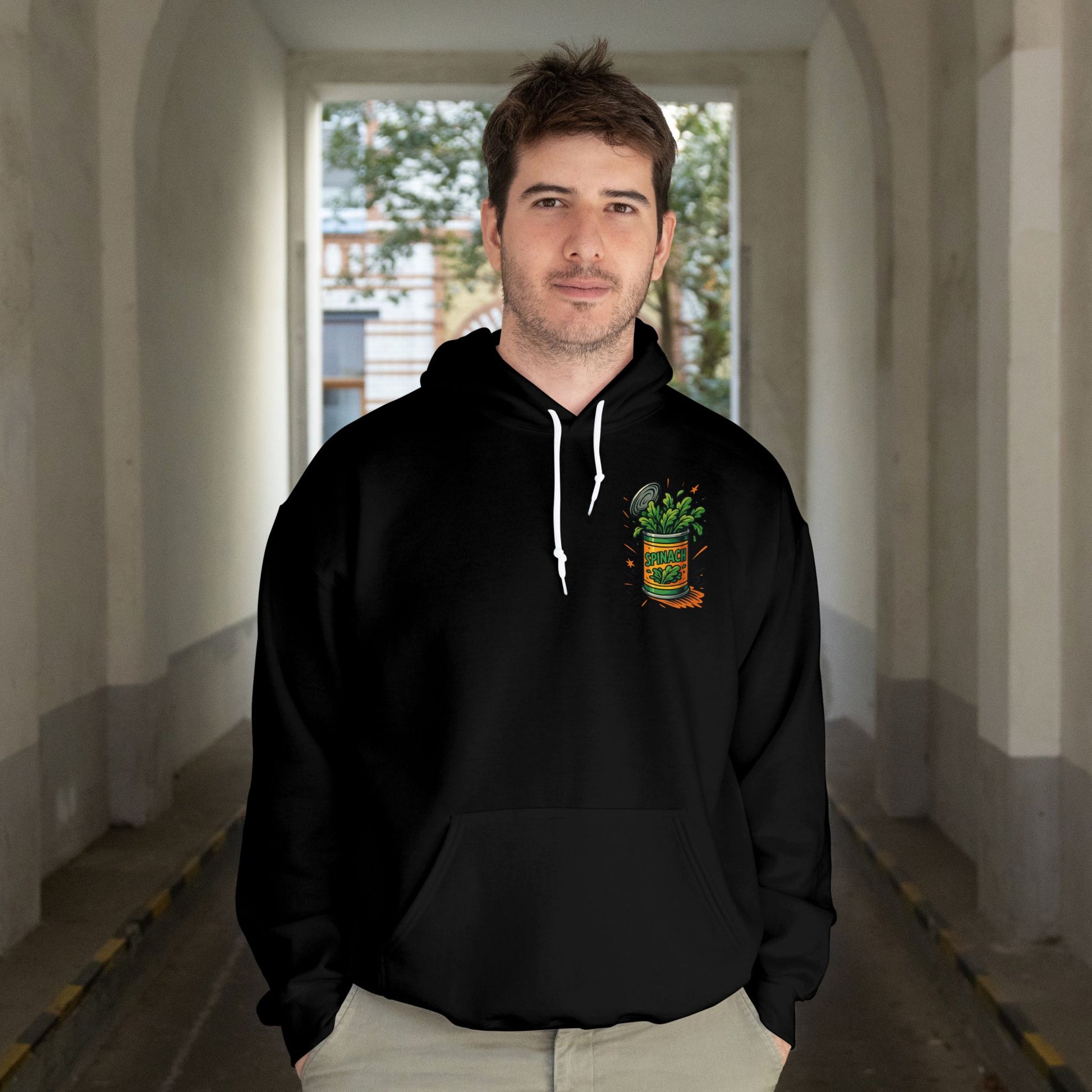 Man wearing a black hoodie with a logo in an indoor setting