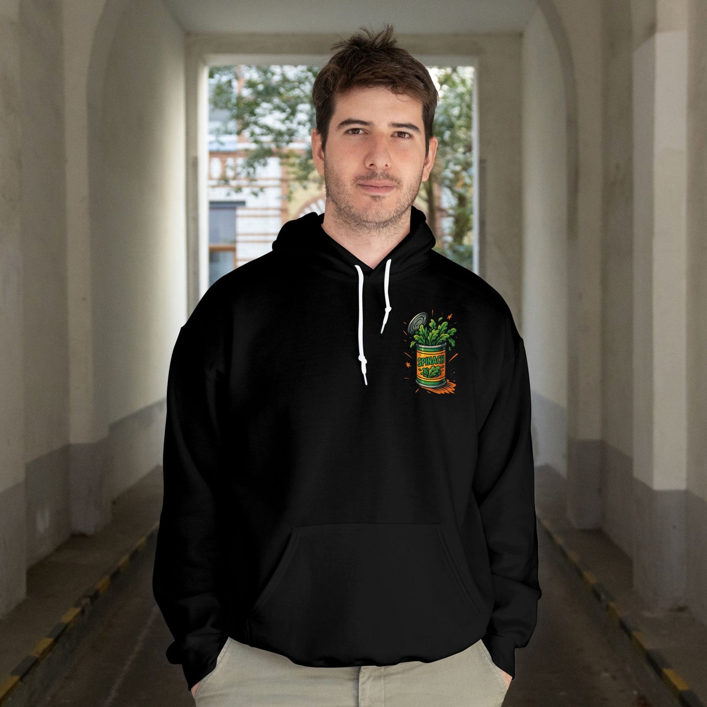 Man wearing a black hoodie with a logo in an indoor setting