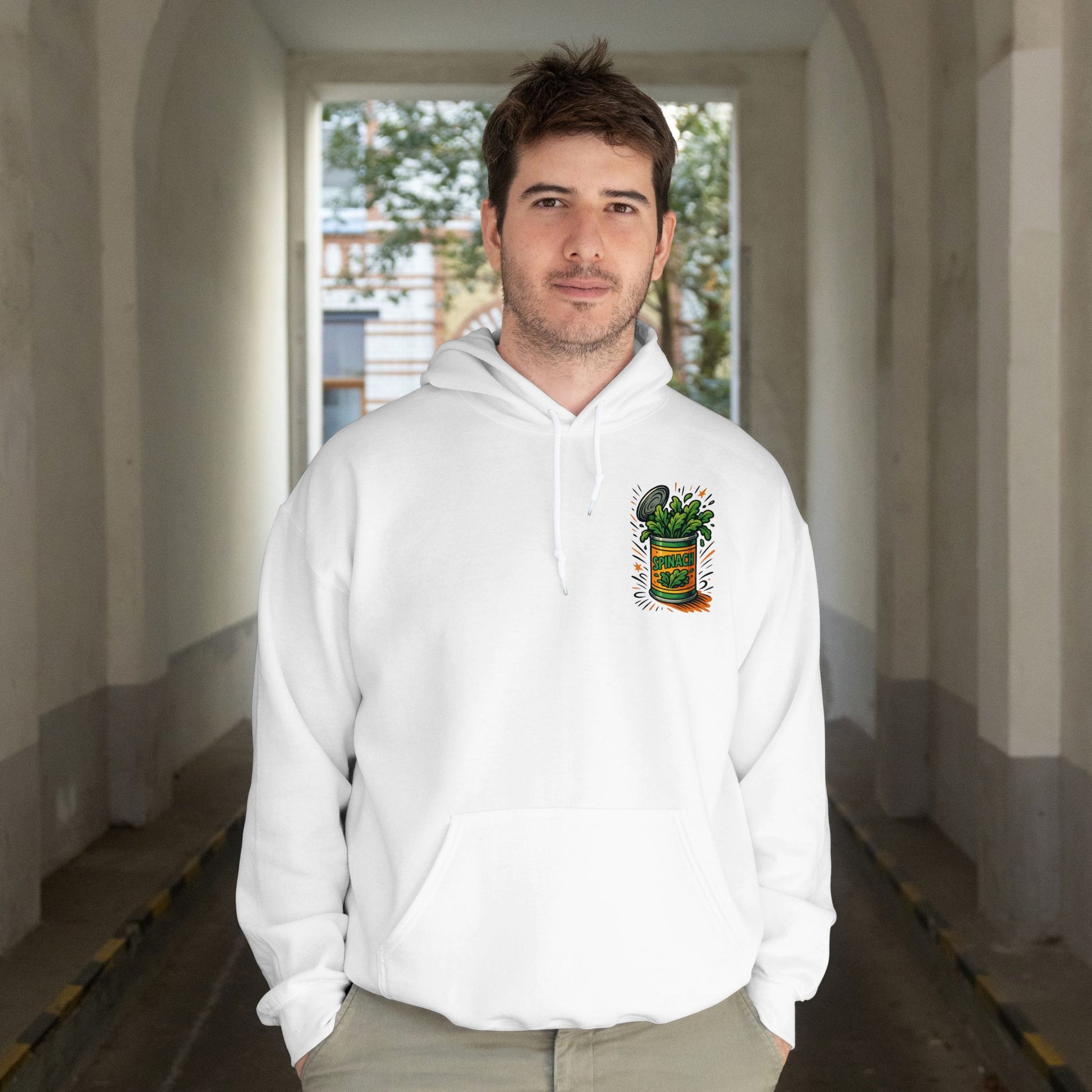 Man wearing a white hoodie with a graphic design in an indoor setting