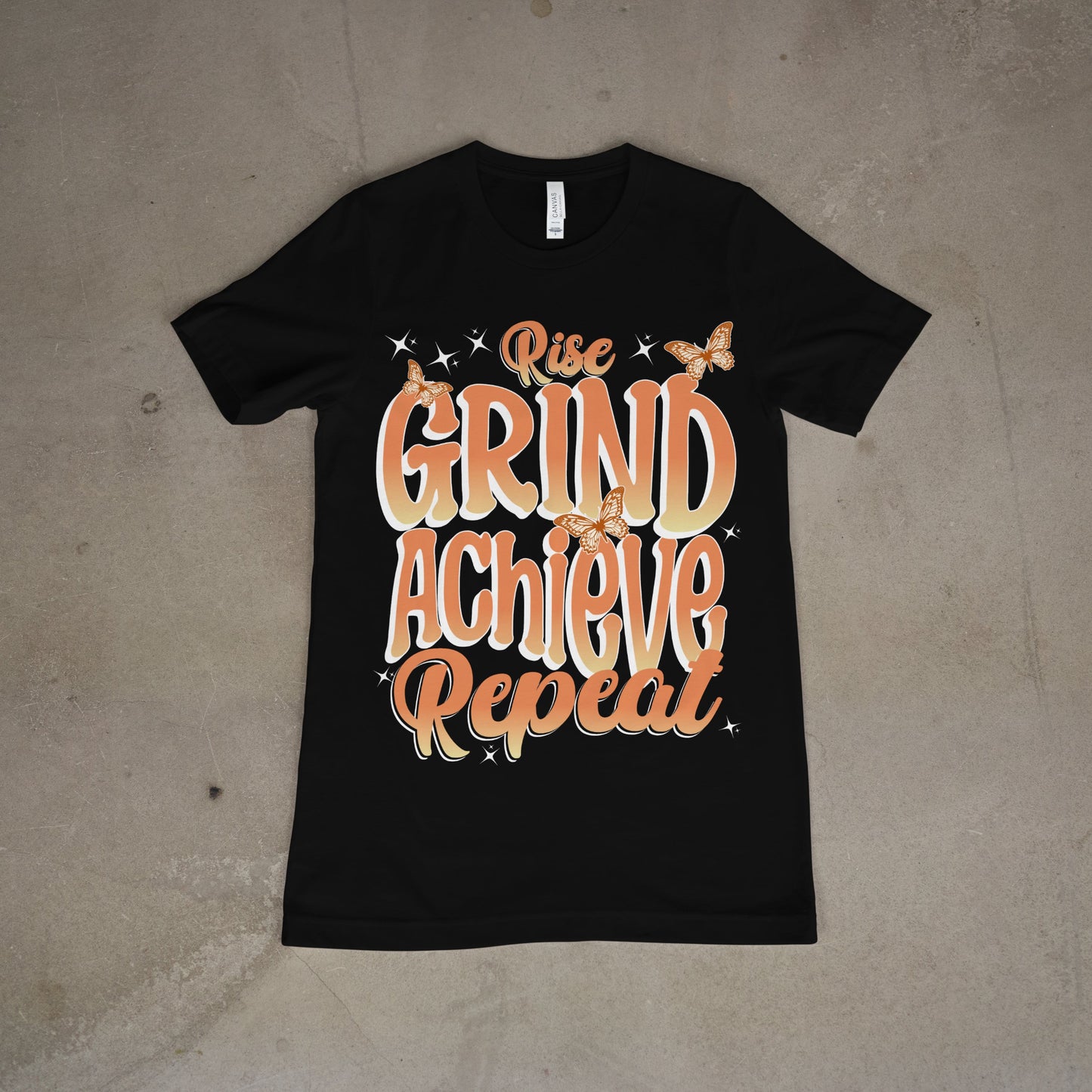 Black t-shirt with bold orange motivational text “Rise, Grind, Achieve, Repeat”