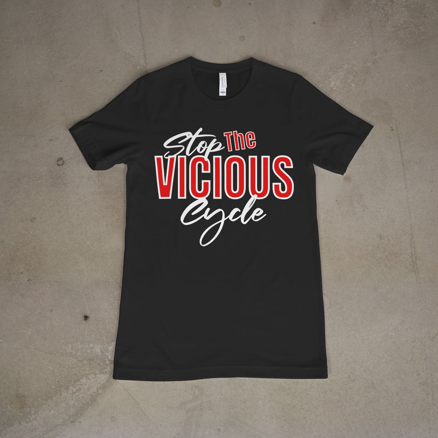 Black t-shirt with 'Stop The Vicious Cycle' text on a beige surface