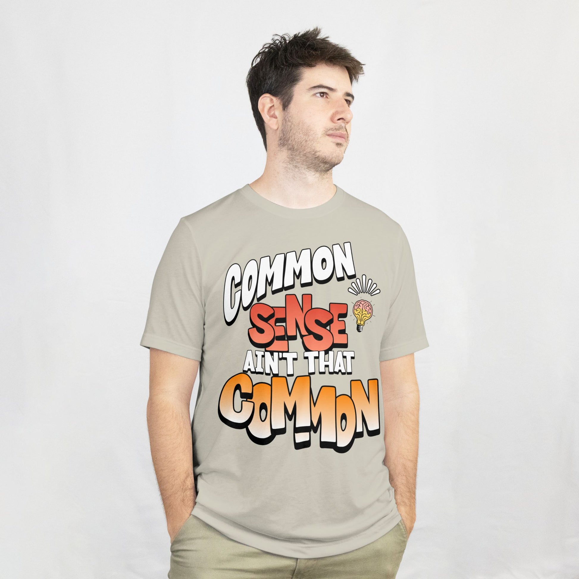 Man wearing a t-shirt with colorful text design on a plain background