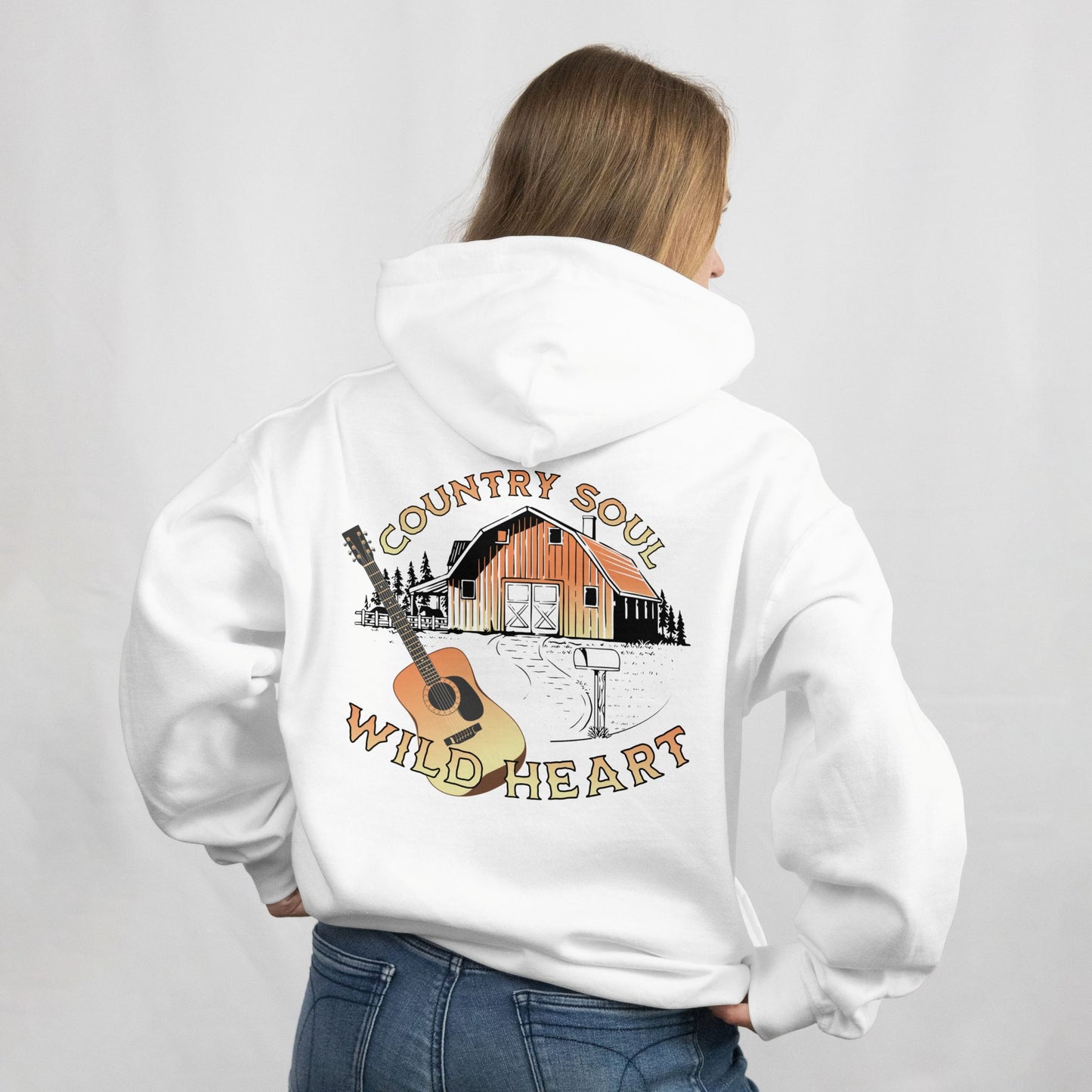 Person wearing a white hoodie with a 'Country Soul Wild Heart' design on the back.