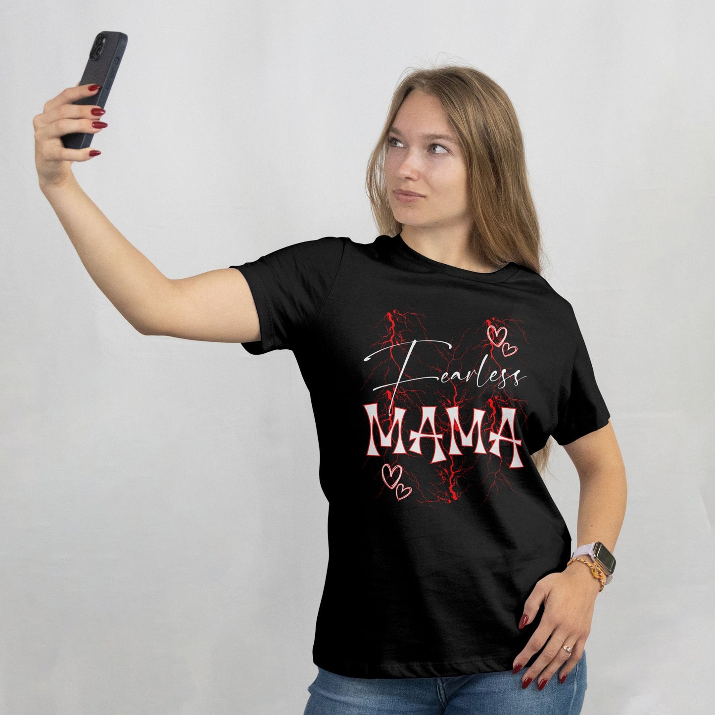 Woman wearing a black t-shirt with 'Fearless MAMA' text, taking a selfie against a plain background