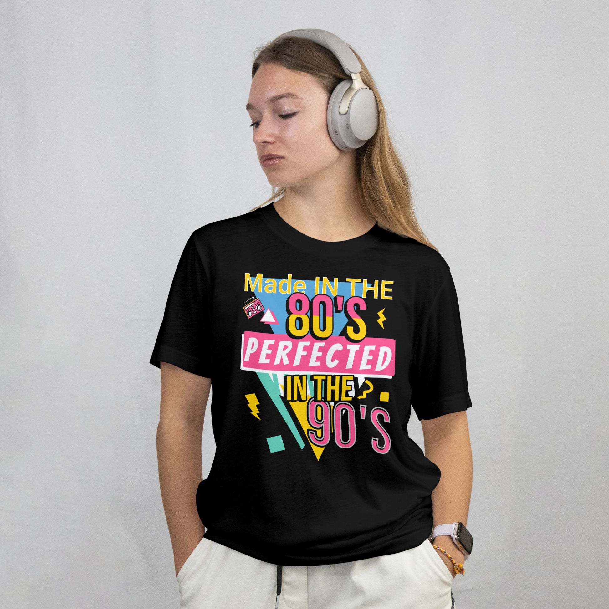 Person wearing a black t-shirt with colorful text design on a plain background