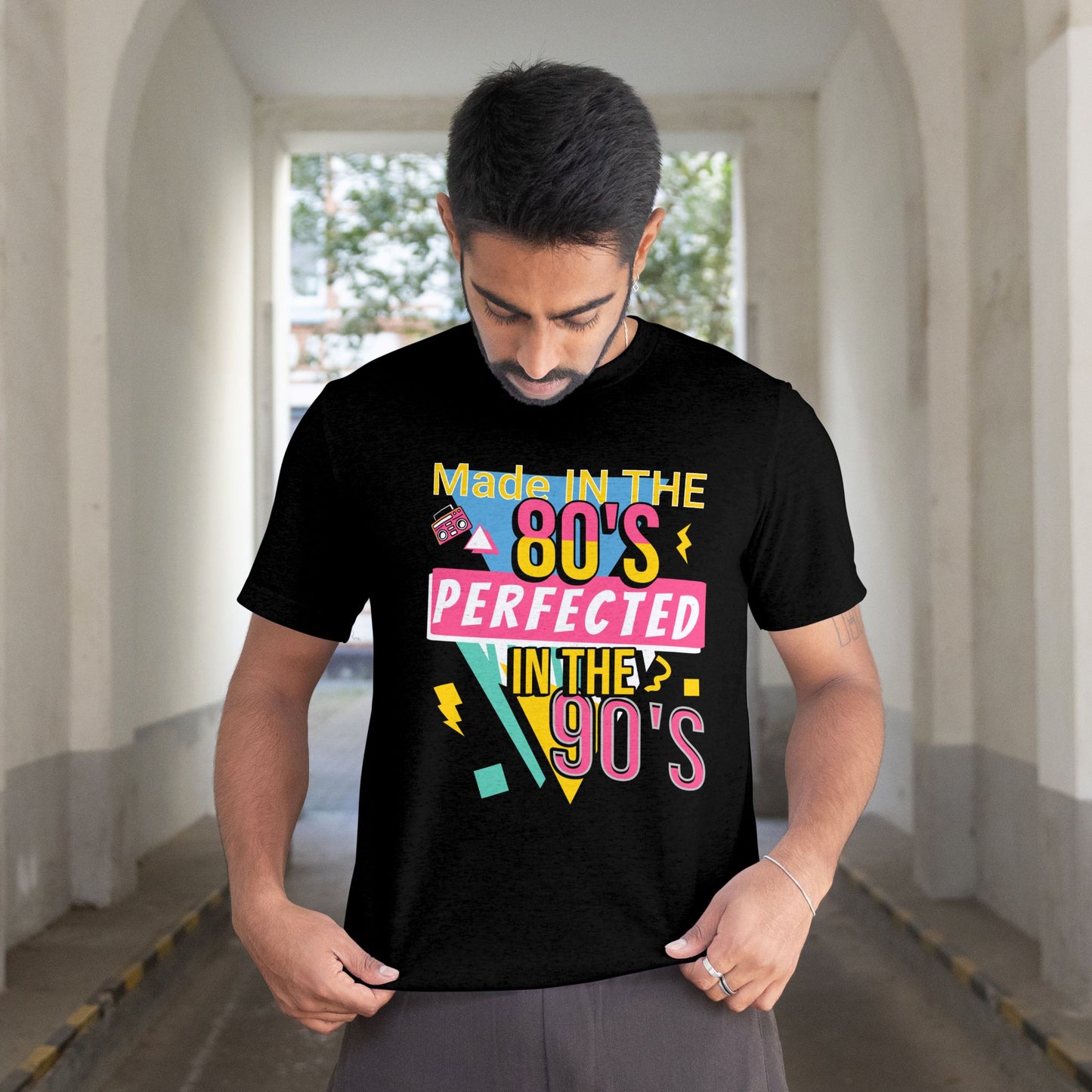 Man wearing a black t-shirt with colorful text in an urban setting