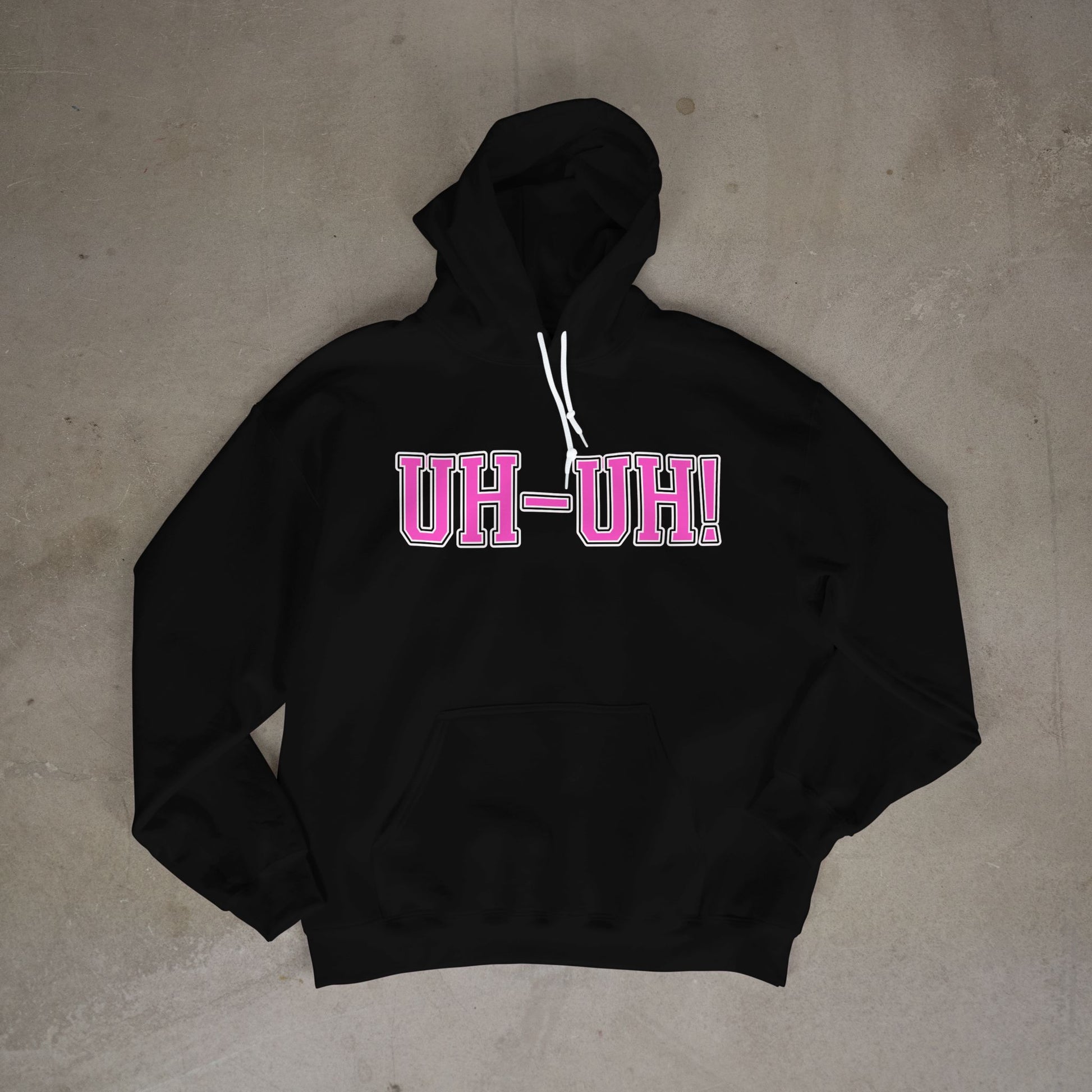 Black hoodie with 'UH-UH!' text in pink on a concrete floor.