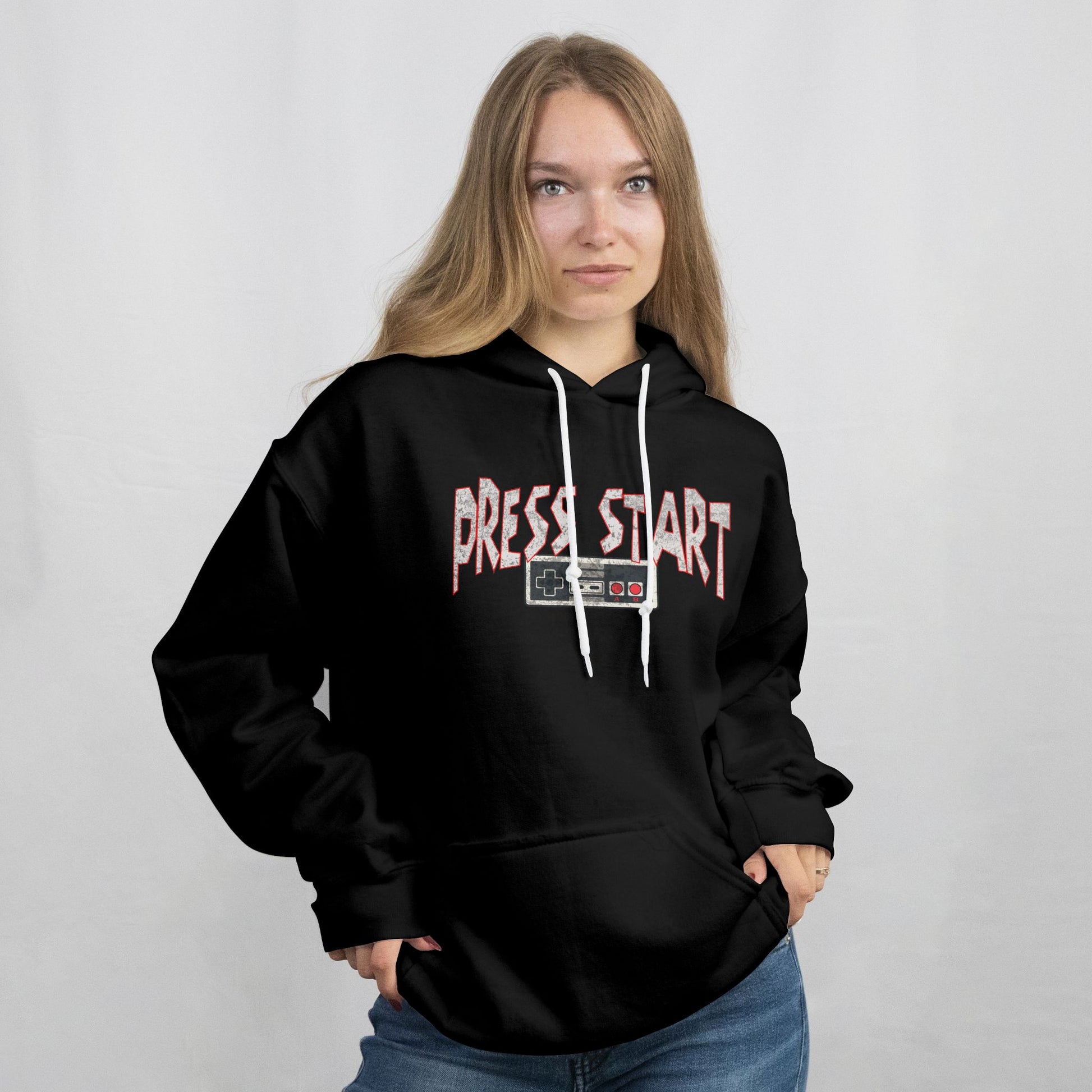 Person wearing a black hoodie with 'PRESS START' text on a plain background
