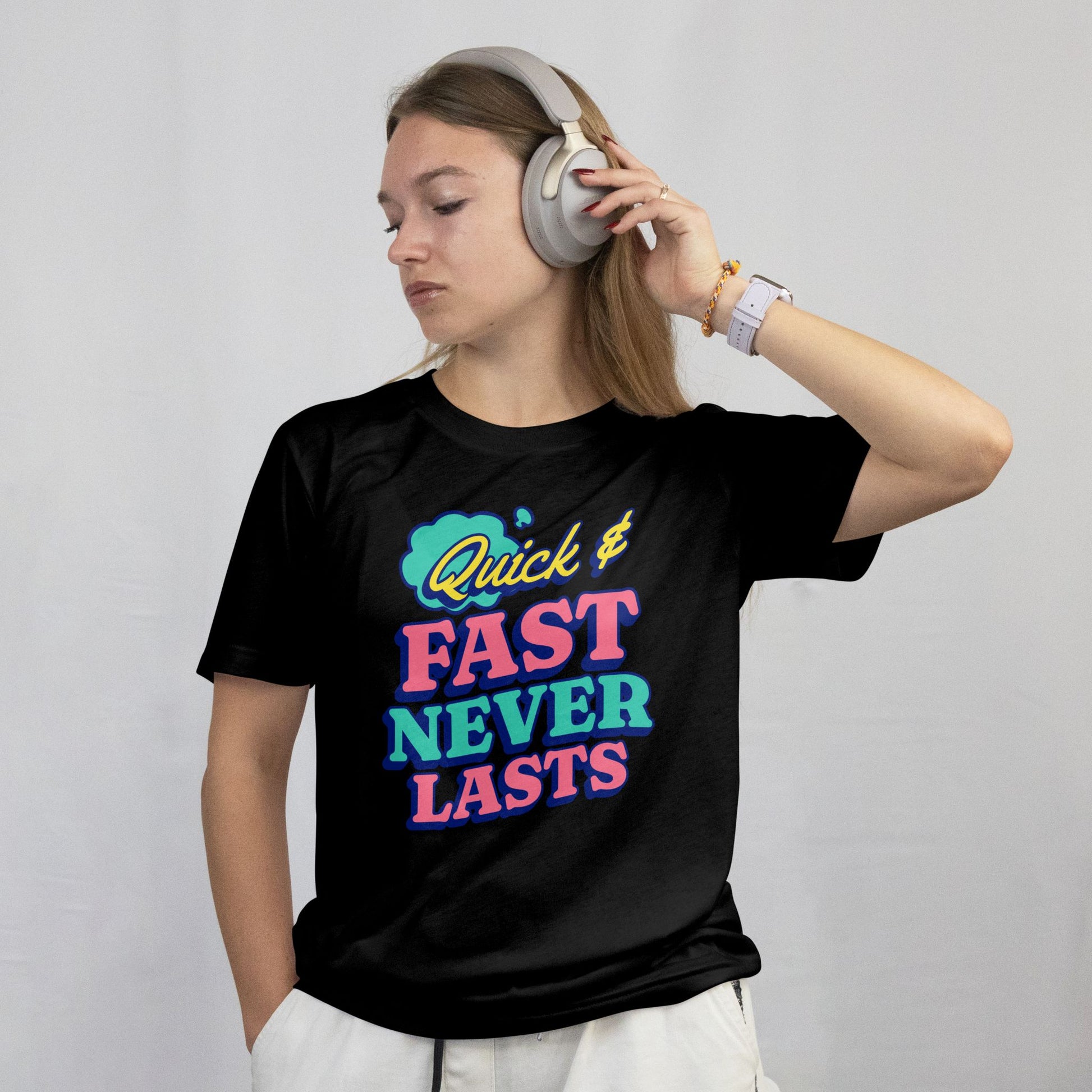Person wearing a black t-shirt with colorful text and headphones on a plain background