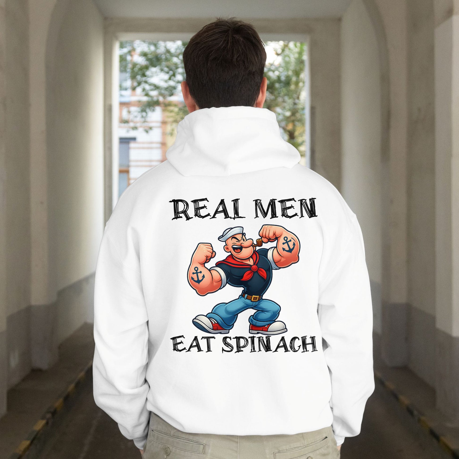 Person wearing a white hoodie with a cartoon character and text on the back, walking down a hallway.