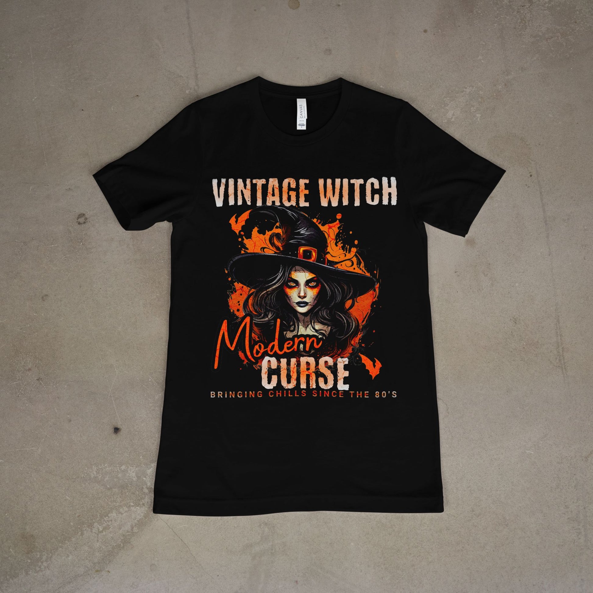 Black t-shirt with witch graphic and text on a concrete floor