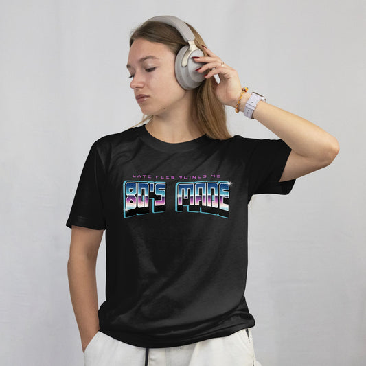 Person wearing a black t-shirt with colorful text design on a plain background