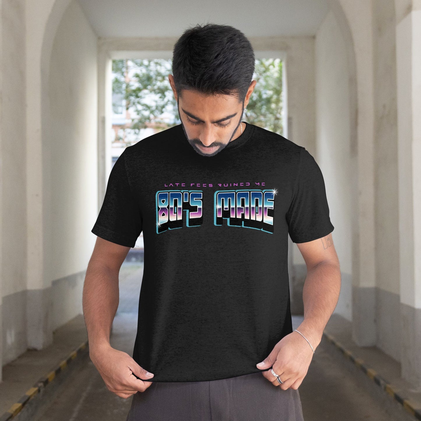 Man wearing a black t-shirt with colorful text in an urban setting