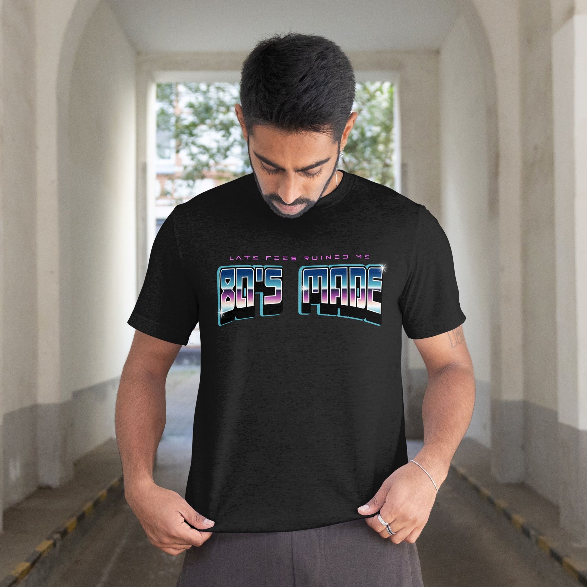 Man wearing a black t-shirt with colorful text in an urban setting