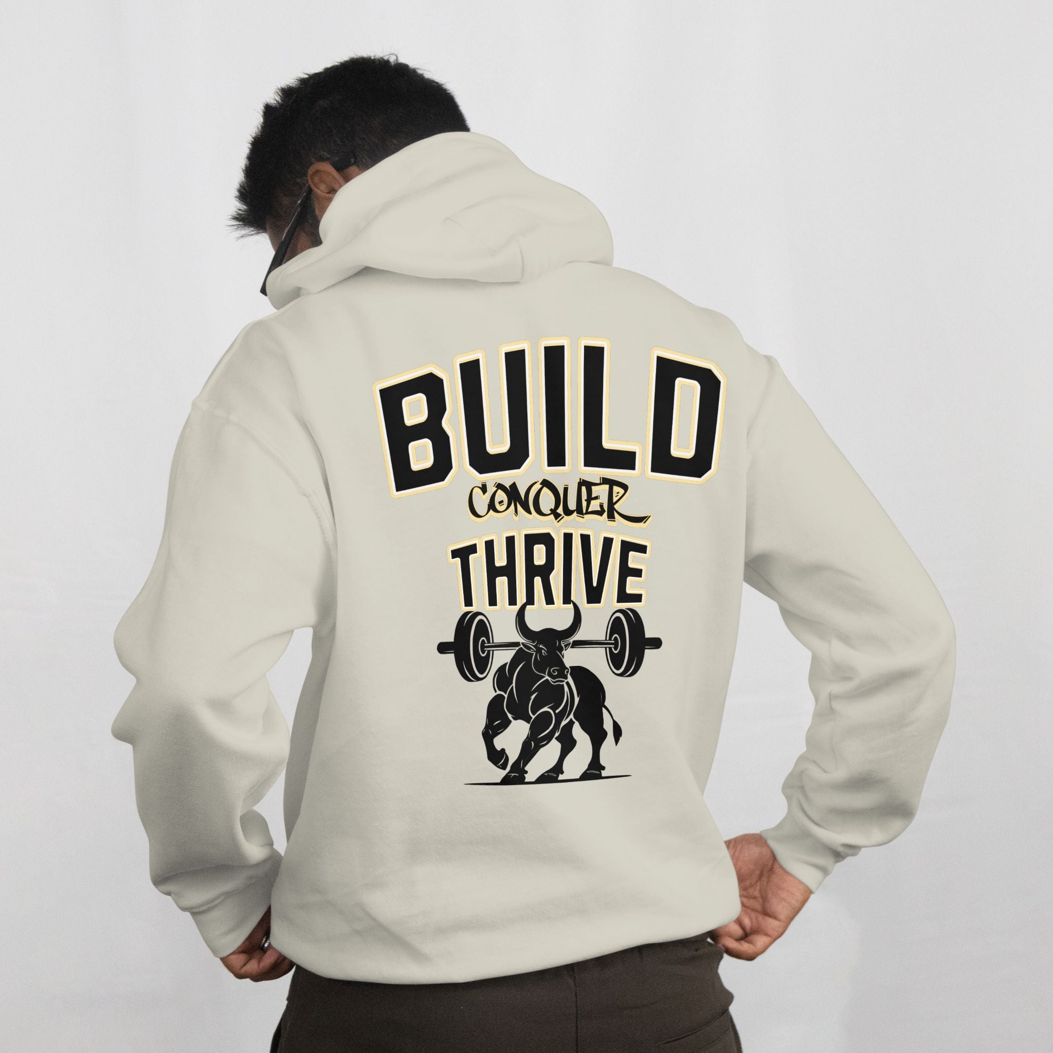 Person wearing a beige hoodie with motivational text and graphic on the back against a white background