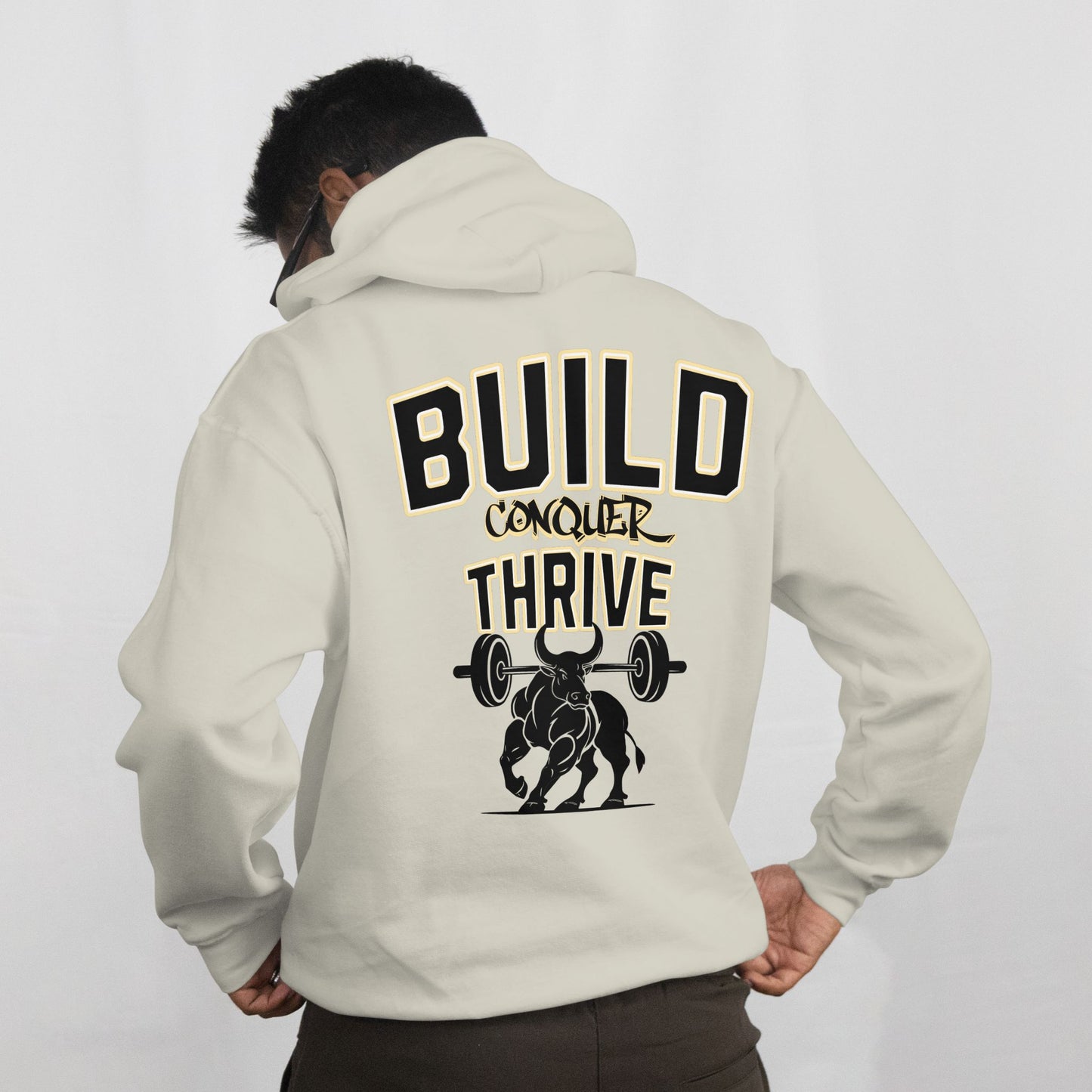 Person wearing a beige hoodie with motivational text and graphic on the back against a white background