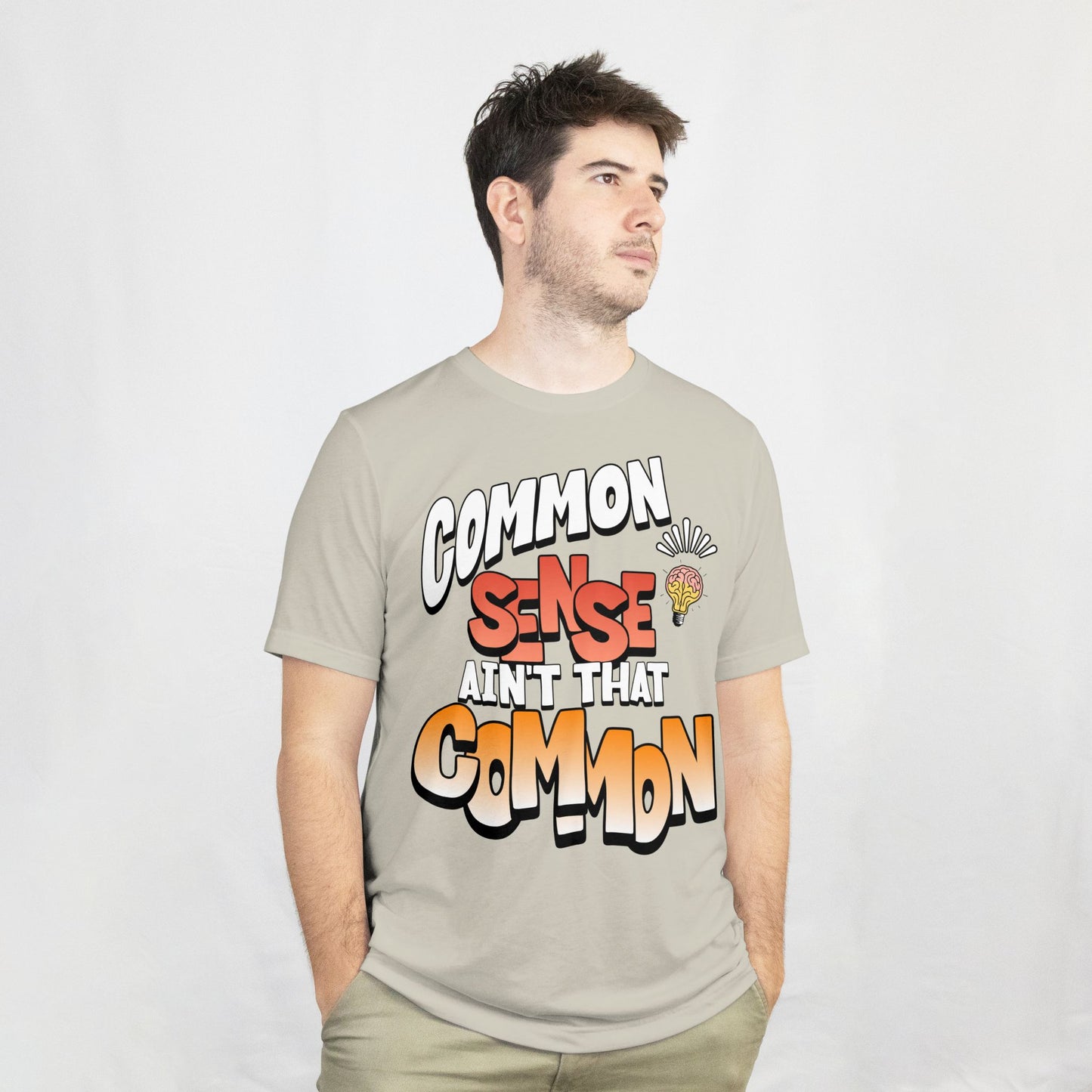 Man wearing a t-shirt with colorful text design on a plain background