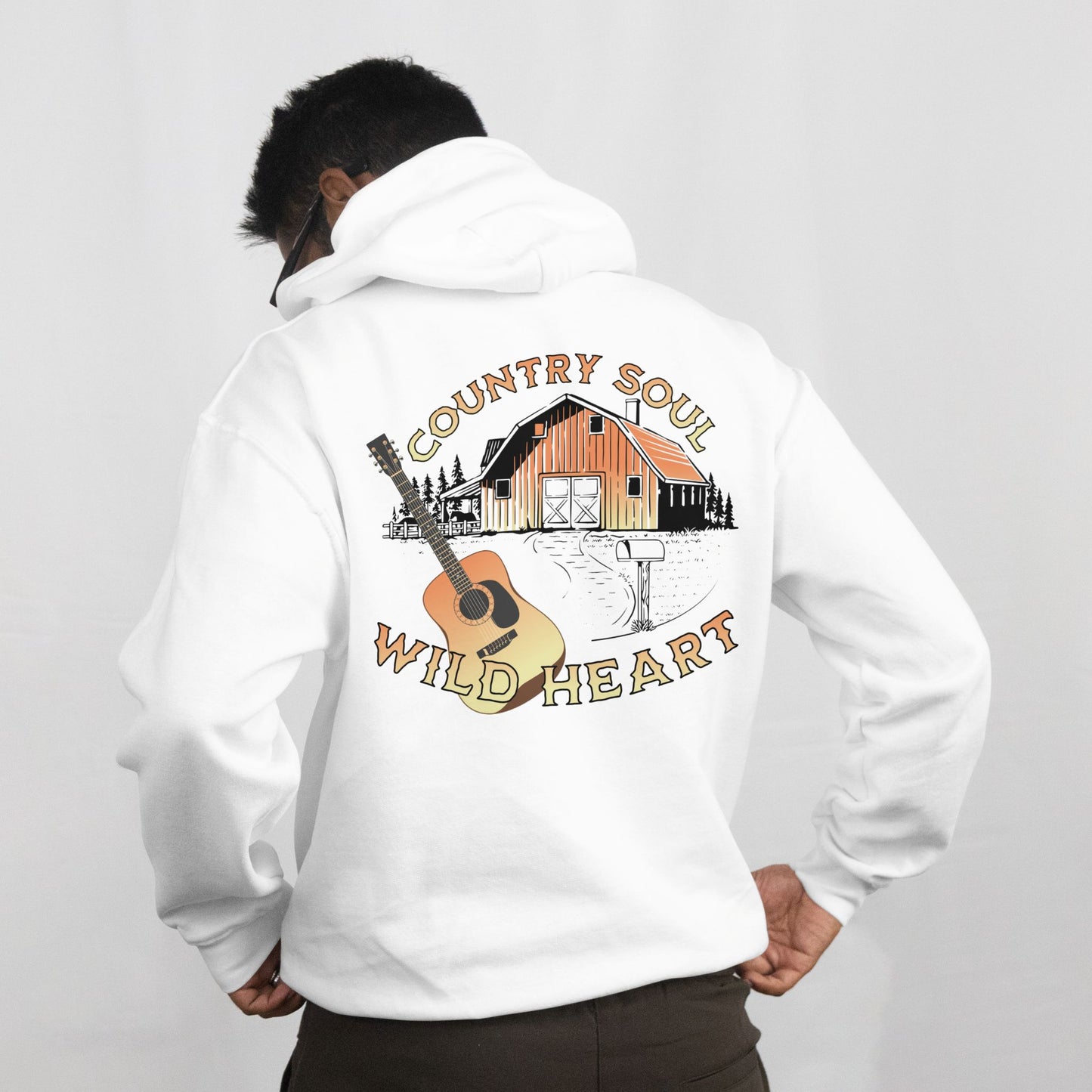 Person wearing a white hoodie with a 'Country Soul, Wild Heart' design on the back.