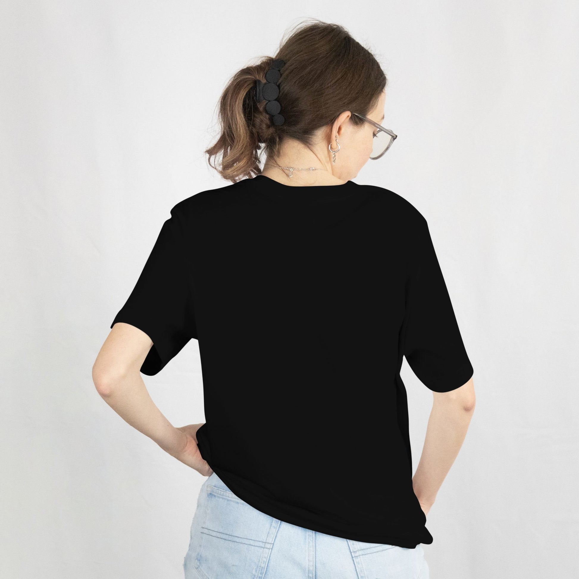 Person wearing a black t-shirt and light blue jeans on a white background