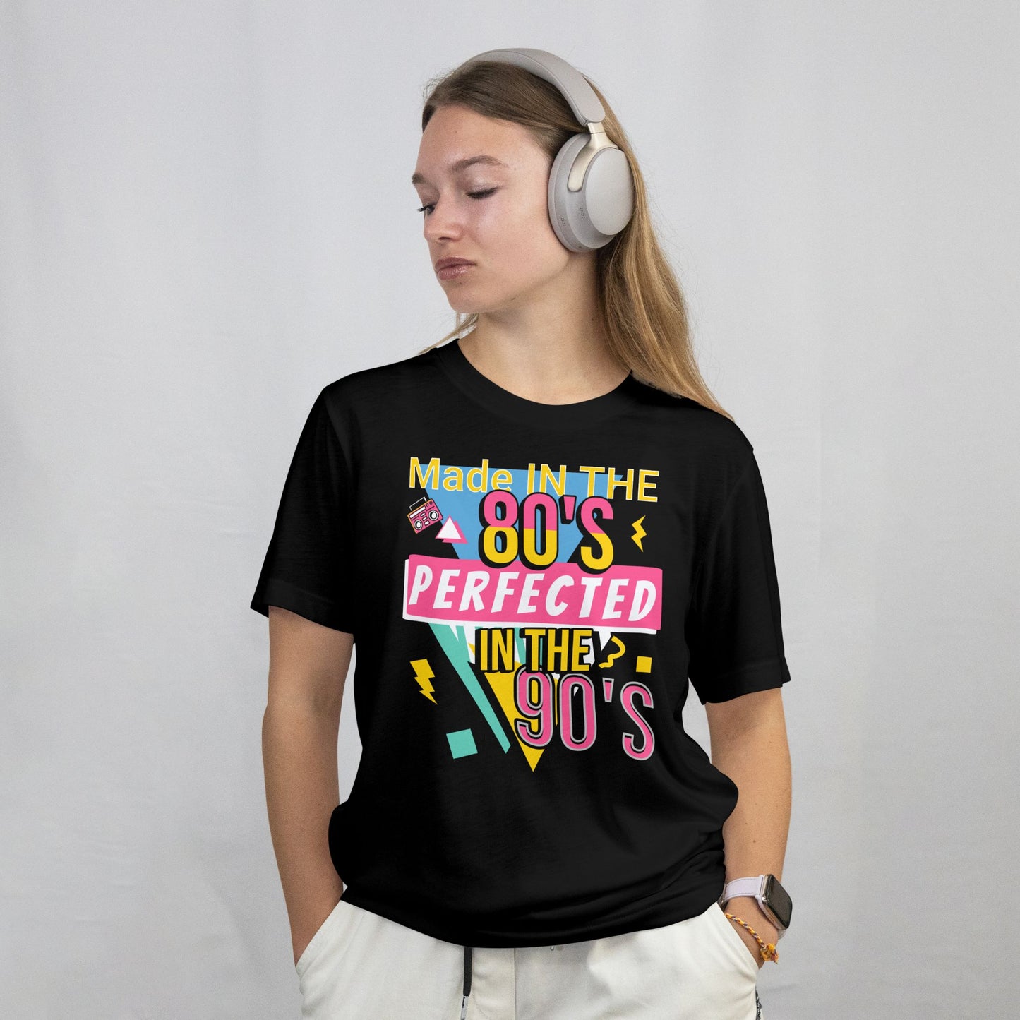 Person wearing a black t-shirt with colorful text design on a plain background