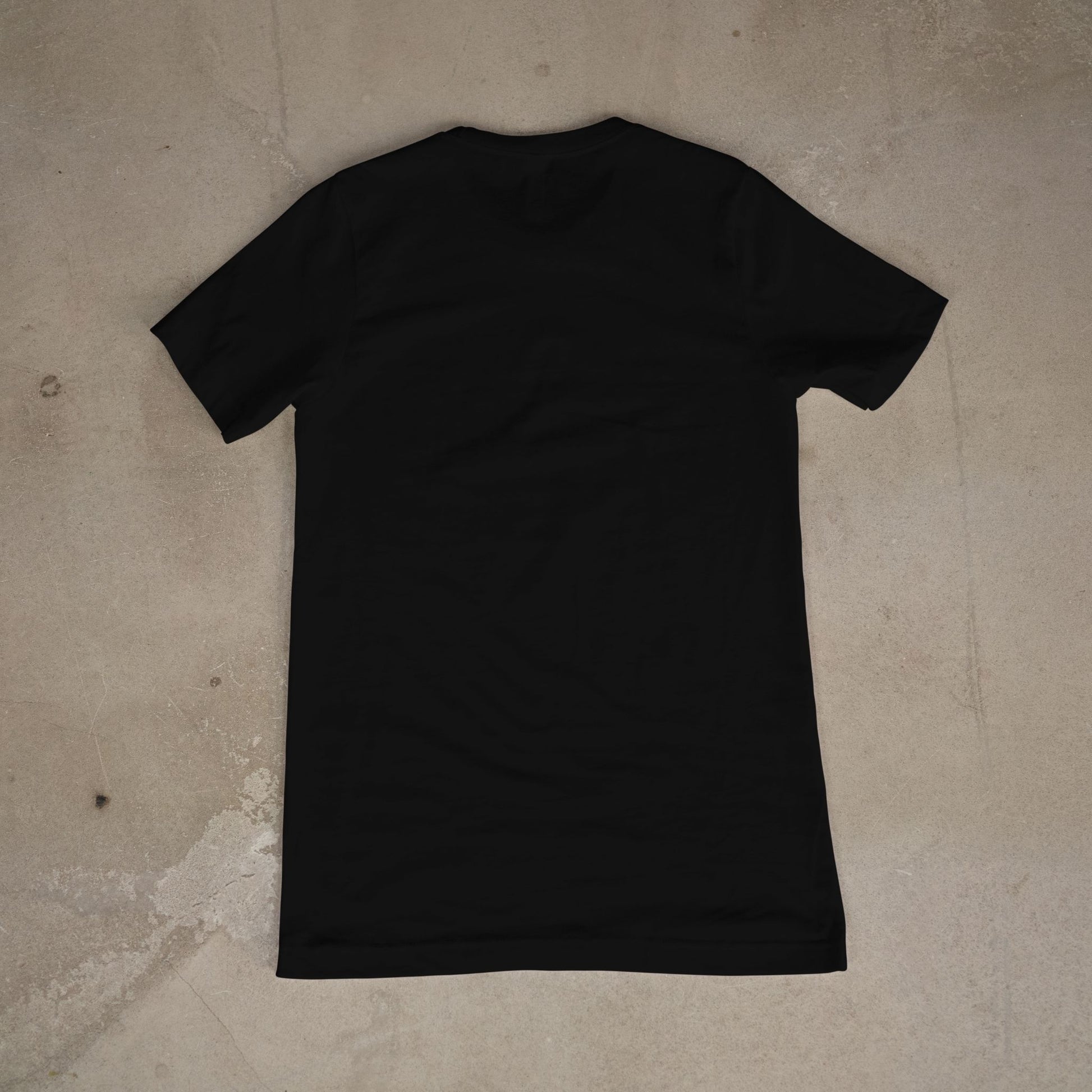 Black t-shirt on a beige concrete floor