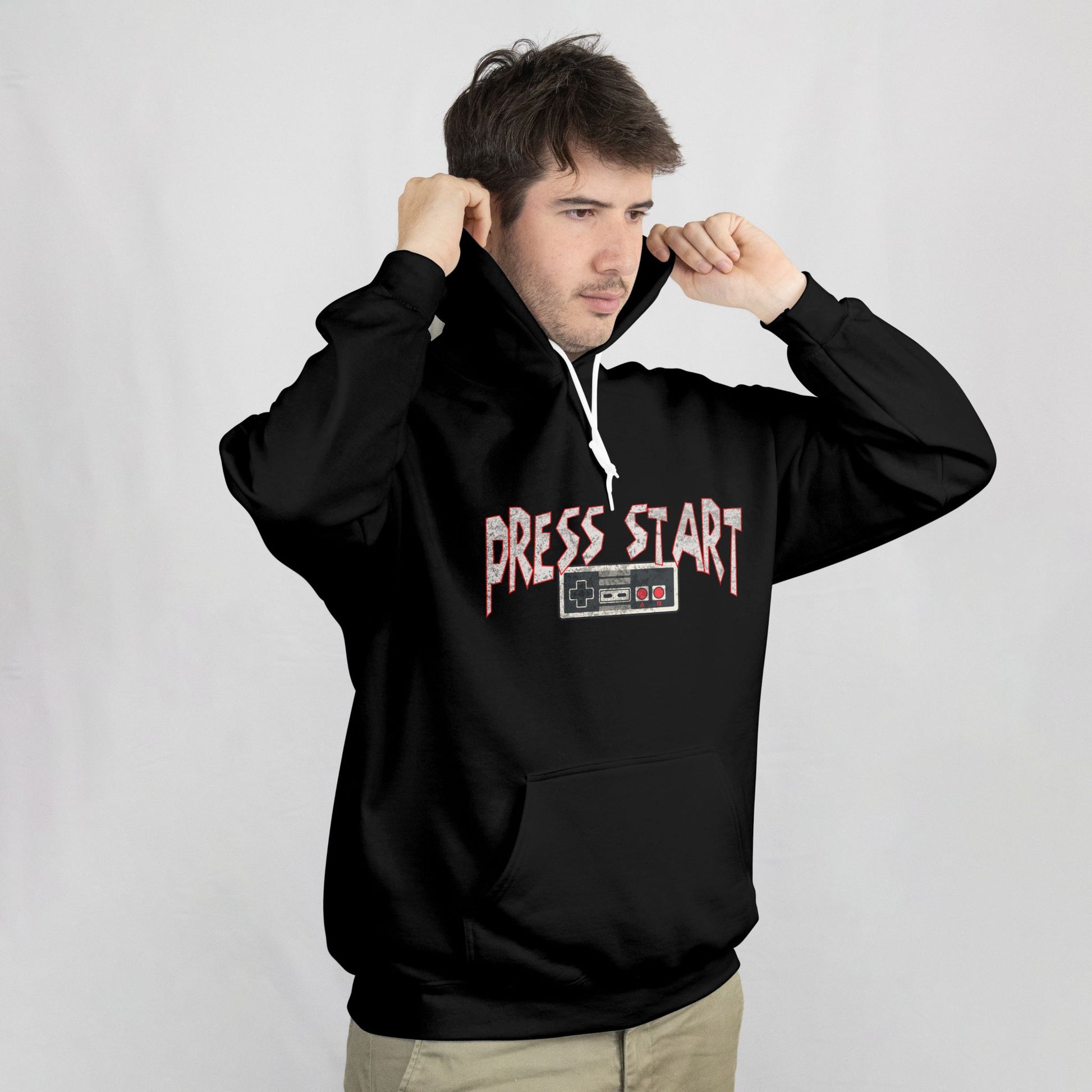 Person wearing a black hoodie with 'Press Start' text on a plain background