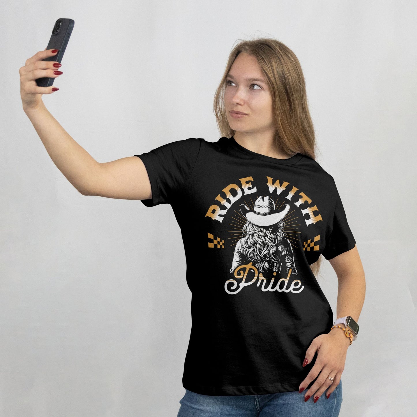 Woman wearing a black t-shirt with 'Ride with Pride' graphic and taking a selfie.