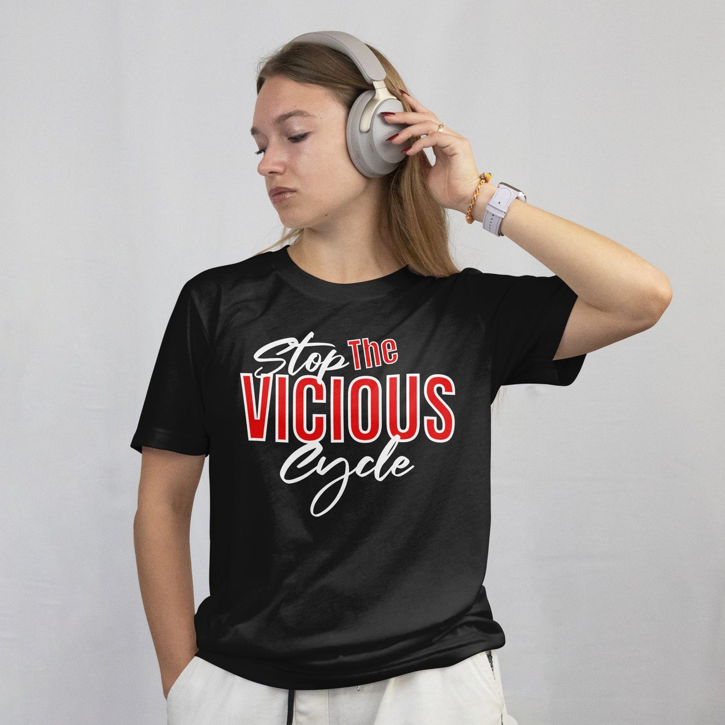 Person wearing a black t-shirt with 'Stop The Vicious Cycle' text, listening to music with headphones.